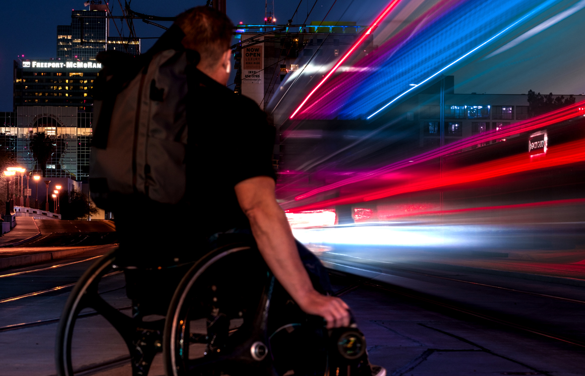 Image of Jade with city in background and long exposure of lightrail on right side