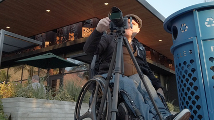 Image of me taking a photo using a tripod during the day to capture a long exposure street photography image.